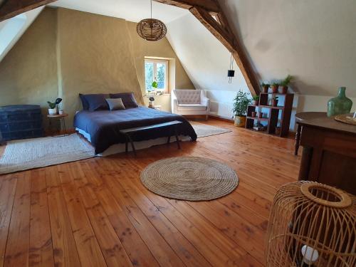 Schlafzimmer mit einem Bett und Holzboden in der Unterkunft Suite familiale 2 chambres in Challuy