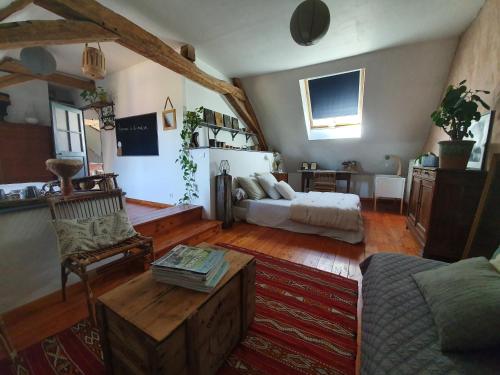 ein Wohnzimmer mit einem Bett, einem Sofa und einem Tisch in der Unterkunft Suite familiale 2 chambres in Challuy