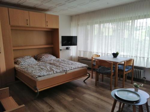 sypialnia z łóżkiem, stołem i biurkiem w obiekcie Haus Gertrud w mieście Schönwald