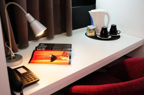 
a desk with a coffee mug and a lamp at Star Inn Porto in Porto
