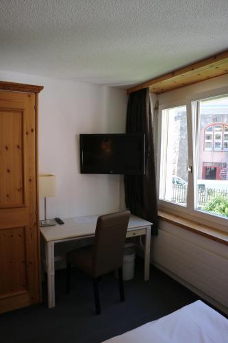 a hotel room with a desk and a window at Spenglers Inn in Davos