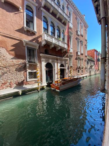 a boat in a canal in front of a building at Ruzzini Palace Hotel in Venice