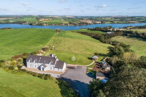 an aerial view of a house on a hill next to a river at Four Winds,Kinsale Town,Exquisite holiday homes,sleeps 26 in Kinsale