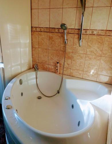 a white bath tub in a bathroom with a shower at гостевой дом у Снежаны in Provadiya