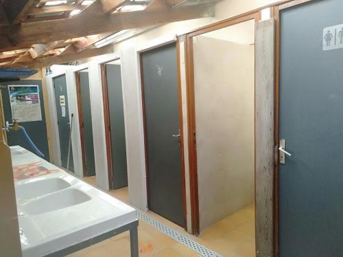 a row of stalls in a room with doors at Camping du lac in Saint-Julien-du-Verdon