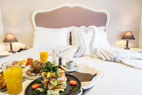 a breakfast plate of food on a bed at Emerald Suites in Florina