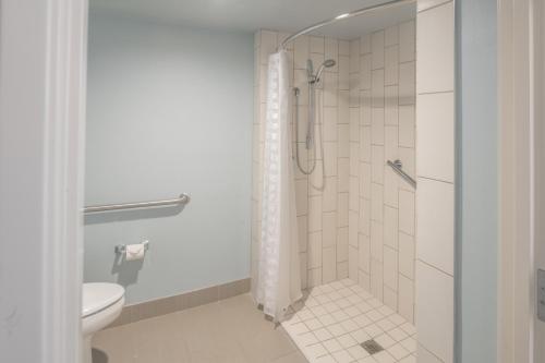 uma casa de banho com um chuveiro e um WC. em Hyatt Place College Station em College Station