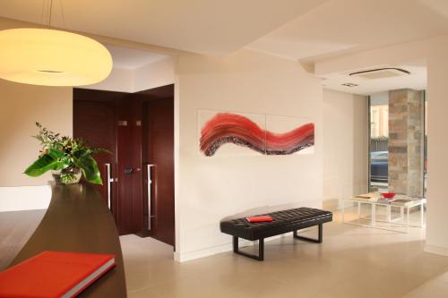 a living room with a bench and a painting on the wall at Residence Hotel Parioli in Rome