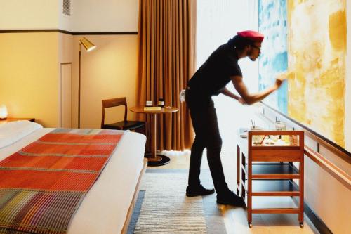 a man in a hotel room looking at a painting at Eaton DC in Washington