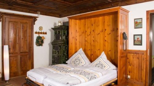 a bed in a room with a wooden wall at Ferienwohnung KraftTanken in Hallstatt