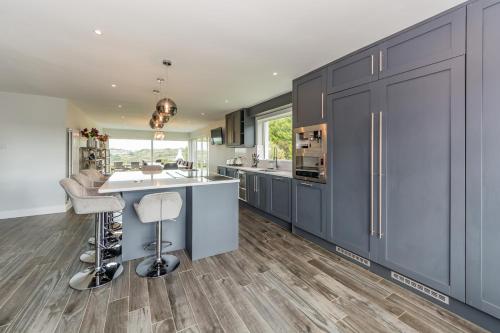 a kitchen with blue cabinets and a kitchen island at Marina views, Kinsale, Hosted by Exquisite holiday homes, sleeps 20 in Kinsale