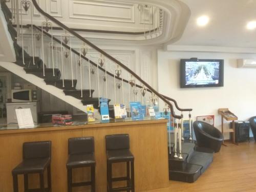 a bar with stools and a staircase in a building at Hotel Paulista in Porto