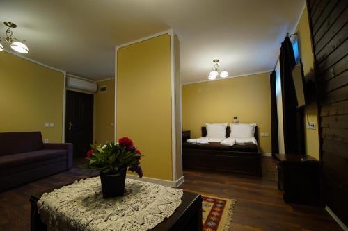 a room with a bed and a table with a vase at Pulpudeva Family Hotel in Plovdiv