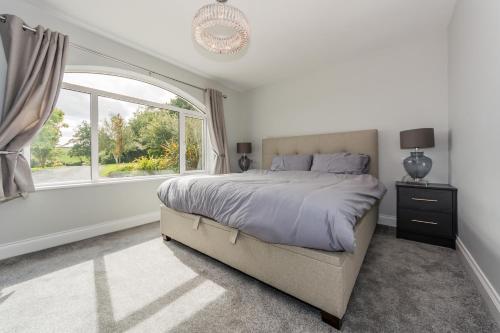 a bedroom with a bed and a large window at Marina views, Kinsale, Hosted by Exquisite holiday homes, sleeps 20 in Kinsale