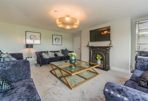 a living room with couches and a table and a fireplace at Marina views, Kinsale, Hosted by Exquisite holiday homes, sleeps 20 in Kinsale