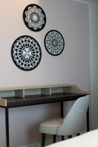 a table with plates on a wall with a chair at Mercure St. Julian's Malta in St Julian's