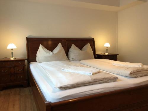 a bedroom with two beds with white sheets and two lamps at CityApartment MELITTA in Schladming