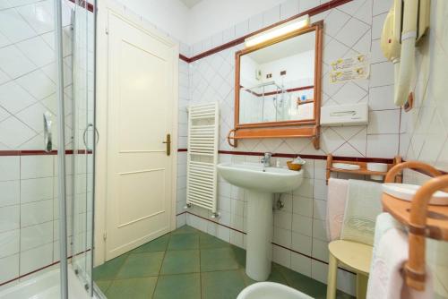 a small bathroom with a sink and a mirror at Hotel Kyrton in Forte dei Marmi