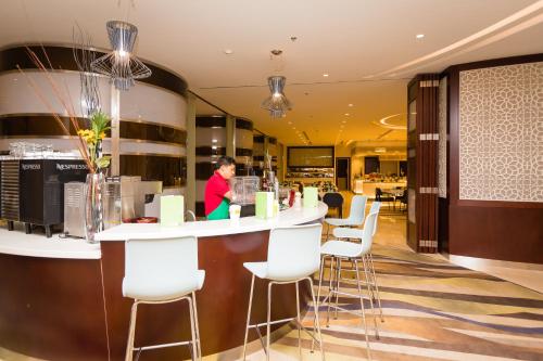 a woman standing at a bar in a restaurant at Holiday Inn Yanbu by IHG in Yanbu