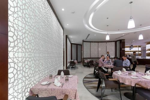 a restaurant with pink tables and people sitting at tables at Holiday Inn Yanbu by IHG in Yanbu