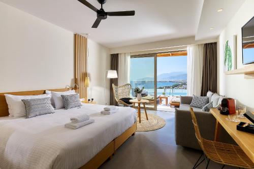 a bedroom with a bed and a desk and a couch at Enorme Santanna Beach in Ierapetra