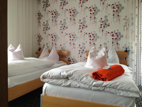 two beds in a hotel room with red balls on the wall at Pottensteiner Stuben Pension Gasthof in Pottenstein