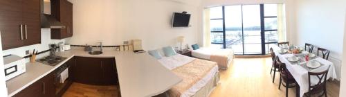 a kitchen and living room with a large window at Carlingford Marina Apartments in Carlingford