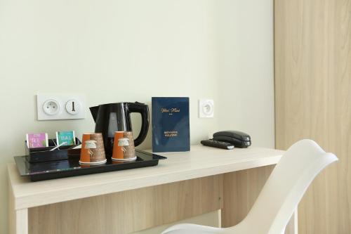 a table with a coffee maker and a chair on it at Murat in Paris