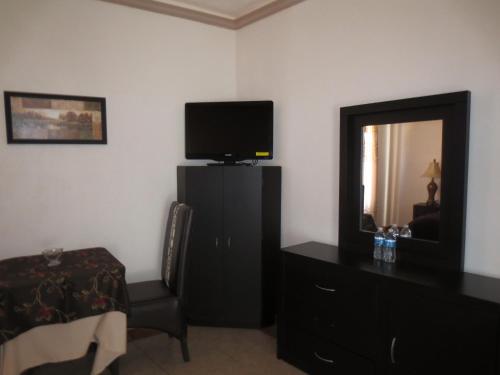 a bedroom with a television and a dresser with a mirror at Casa Celia Hotel Restaurante in Bernal