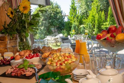 a table topped with bowls of fruit and other food at Wellnesshotel Sonnenhof & Sonnhalde in Ühlingen-Birkendorf
