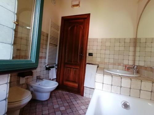 a bathroom with a toilet and a sink and a mirror at Villa Daniela in Riva di Solto