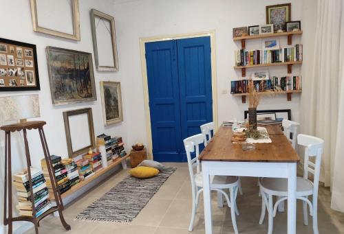 a dining room with a blue door and a table and chairs at Anastasia Hotel in Symi