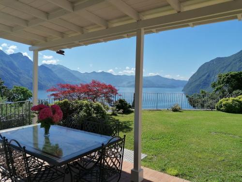 a table on a porch with a view of the water at Villa Daniela in Riva di Solto