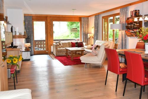 a kitchen and living room with a table and chairs at Monami Apartments Klosters, Apartment 638 Silvretta Parkhotel in Klosters