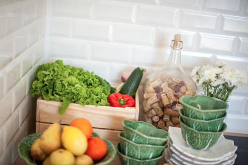 a bunch of fruits and vegetables on a counter with a bottle at The Black Kitten II in Caldas da Rainha