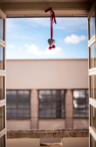 a window view of a building with a red ribbon at The Black Kitten II in Caldas da Rainha