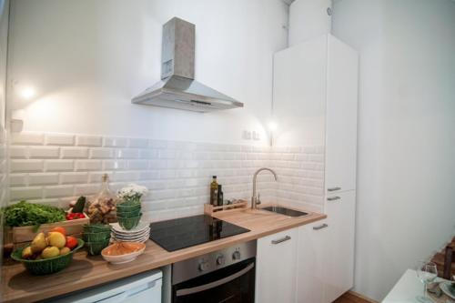 a kitchen with a sink and a counter with fruits and vegetables at The Black Kitten II in Caldas da Rainha