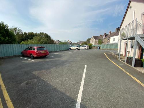 a parking lot with a red car parked in it at Flambards Hotel in Cardigan
