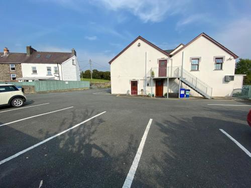 a car parked in a parking lot next to a house at Flambards Hotel in Cardigan