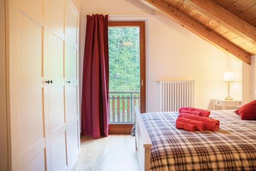 a bedroom with a bed with red pillows on it at Mansarda Villa Adele in Santo Stefano dʼAveto