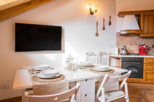 a kitchen with a table with chairs and a tv at Mansarda Villa Adele in Santo Stefano dʼAveto