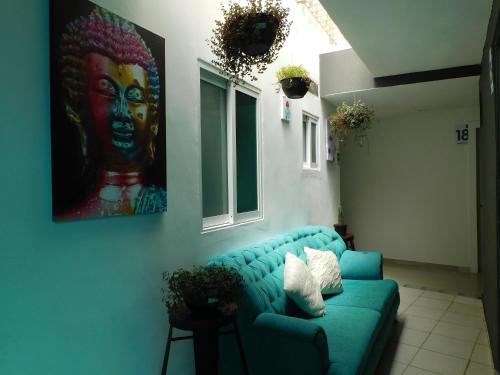 a blue couch in a room with a painting on the wall at Zyan Rooms in Villahermosa