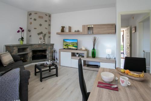 a living room with a table and a fireplace at El Boix in Santa Maria de Besora