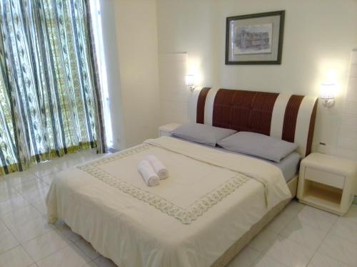 a bedroom with a bed with two pillows on it at Costa Mahkota (Family Homestay) @ Mahkota Melaka in Melaka