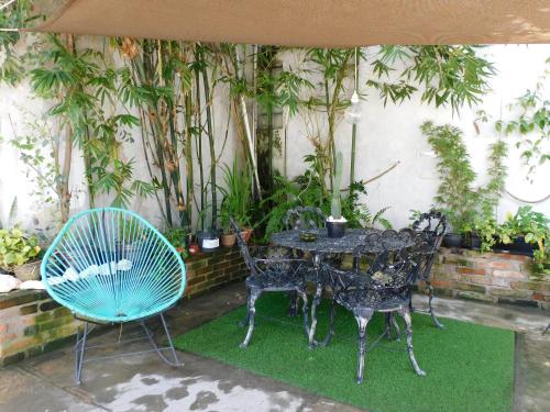 a table and chairs in a garden with plants at Zyan Rooms in Villahermosa