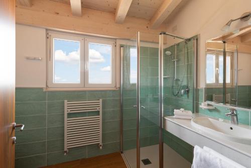 a bathroom with a glass shower and a sink at Hotel Palme & Suite in Garda