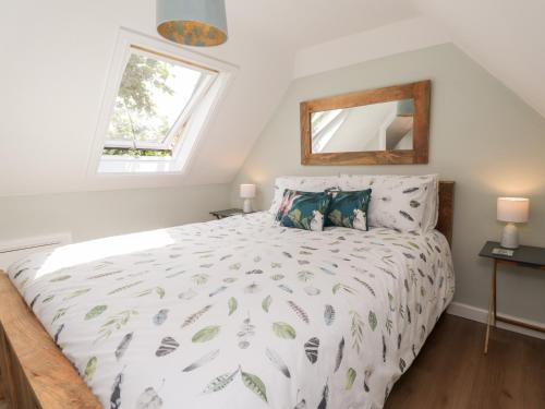 1 dormitorio con 1 cama blanca grande y ventana en Ella's Loft en Canterbury