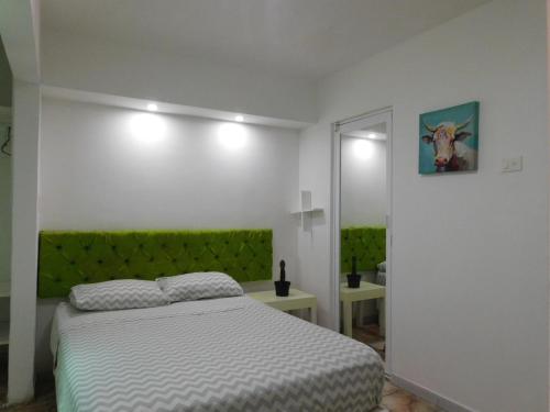 a bedroom with a bed and a green headboard at Zyan Rooms in Villahermosa