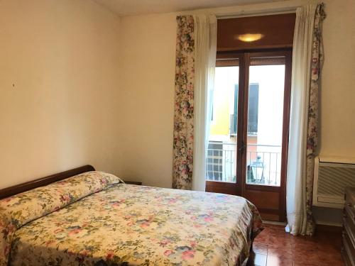 - une chambre avec un lit doté d'un couvre-lit floral et d'une fenêtre dans l'établissement Porto di Ponza - Immobilevante, à Ponza