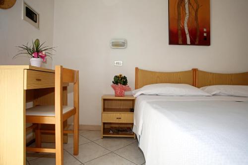 a bedroom with a bed and a desk and a bed at Hotel Serafini Misano Adriatico in Misano Adriatico